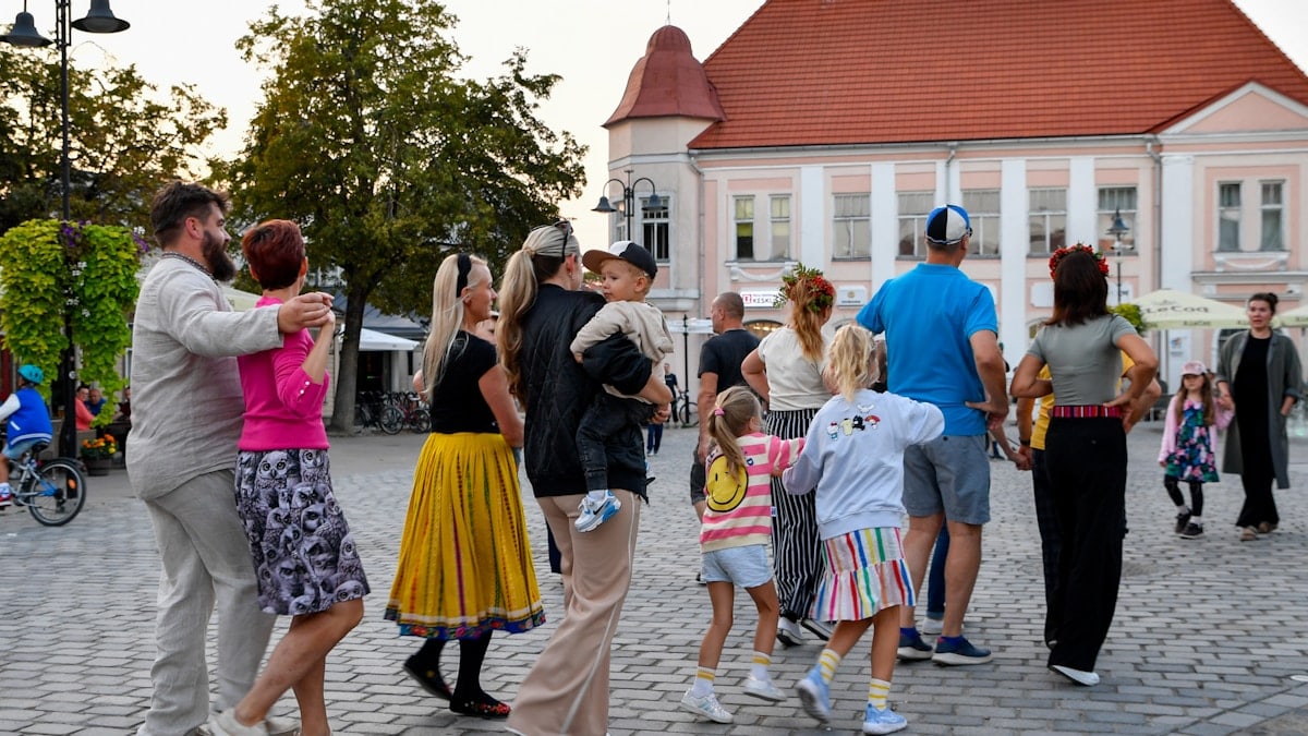 A lively and joyful community dance at the Kuressaare Street Food Festival on Saaremaa island, Estonia, where locals and visitors of all ages gather in the historic town square to celebrate with music and movement.